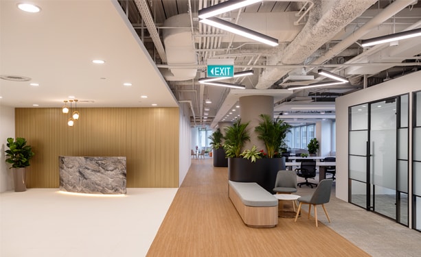 Modern office corridor with glass partitions and lounge seating